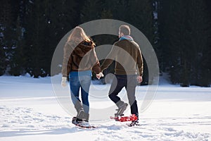 Couple having fun and walking in snow shoes