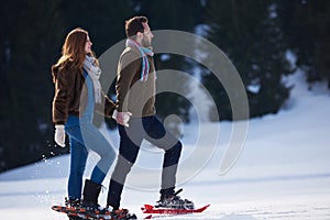 Couple having fun and walking in snow shoes