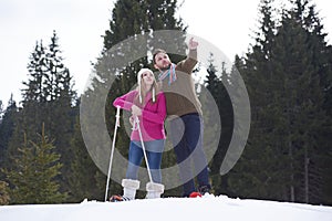 Couple having fun and walking in snow shoes