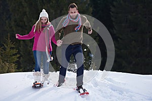 Couple having fun and walking in snow shoes