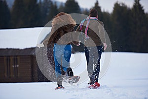 Couple having fun and walking in snow shoes