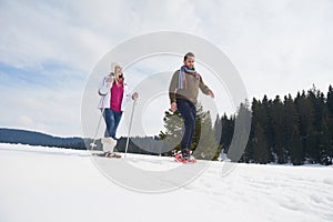 Couple having fun and walking in snow shoes