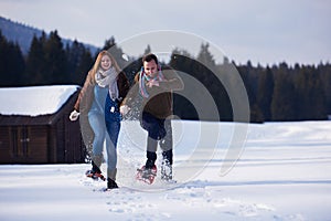 Couple having fun and walking in snow shoes