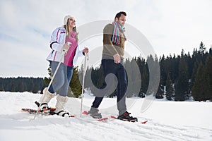 Couple having fun and walking in snow shoes