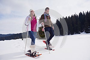 Couple having fun and walking in snow shoes