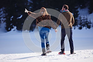 Couple having fun and walking in snow shoes