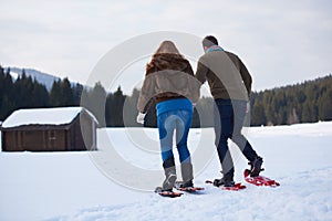 Couple having fun and walking in snow shoes