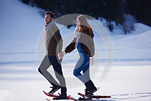 Couple having fun and walking in snow shoes