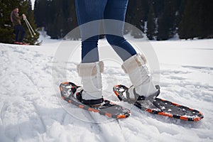 Couple having fun and walking in snow shoes