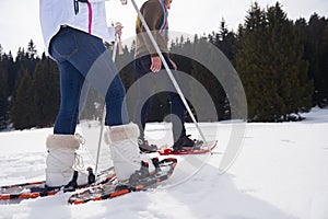 Couple having fun and walking in snow shoes