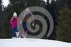 Couple having fun and walking in snow shoes