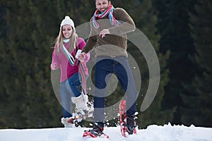 Couple having fun and walking in snow shoes