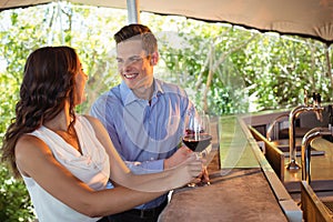 Couple having a glass of red wine at counter