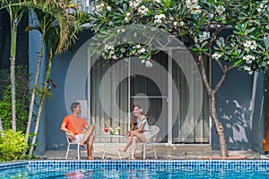 Couple having goodtime together on summer vacation in resort and hotel garden beside pool