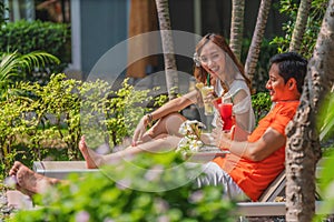 Couple having goodtime together on summer vacation in resort and hotel garden beside pool photo