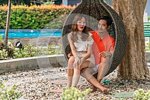 Couple having goodtime together on summer vacation in resort and hotel garden beside pool photo