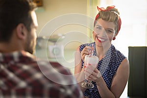 Couple having milkshake in restaurant