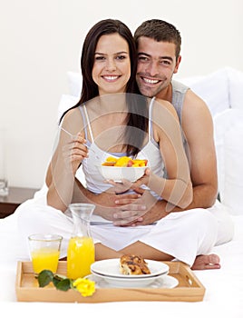 Couple having nutritive breakfast in bed