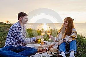 Couple having picnic on green lawn with a sea view