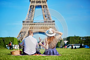 Couple having picnic near the Eiffel tower in Paris, France