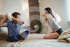 Couple having a pillow fight on bed