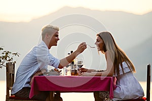 Couple is having a private event dinner on a tropical beach during sunset time