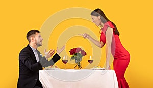 Couple Having Quarrel During Romantic Date On Yellow Studio Background