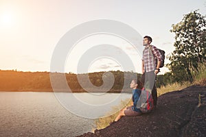 Couple having rest on the top of mountain below lake view during