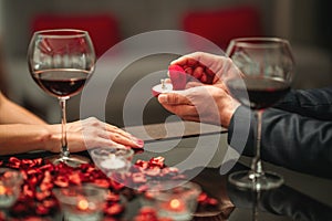 A couple having a romantic dinner and a suprise proposal in a elegance restaurant with beautiful decoration. Romance and