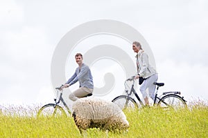 Couple having sea coast bicycle tour at levee