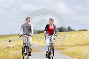 Couple having sea coast bicycle tour at levee photo