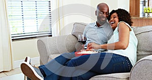 Couple having snacks while watching television in living room 4k