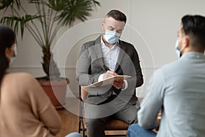 Couple having therapy session with therapist, man writing