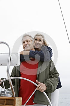 Couple At Helm Of Sailboat