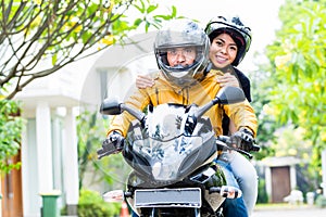 Couple with helmets riding motorcycle