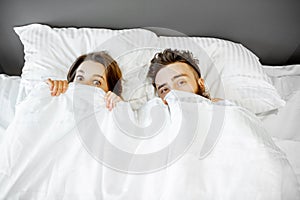 Couple hiding under the sheets