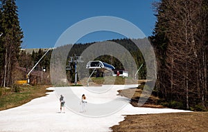 Couple of hikers in casual clothes walking up the snow in the mountains on a sunny spring day