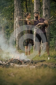 Couple of hikers make bonfire in forest