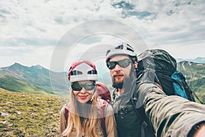 Couple hikers Man and Woman together taking selfie climbing in mountains Travel Lifestyle concept tourists wearing helmet