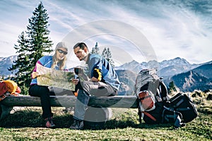 Couple hikers with map in mountains