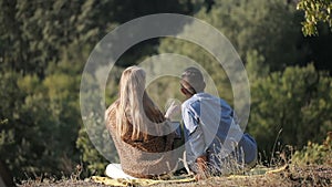 Couple of hikers resting near the tent in the warm sunshine