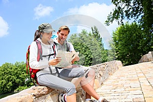 Couple of hikers sitting on bridge