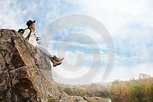 Couple of hikers sitting on steep cliff outdoors