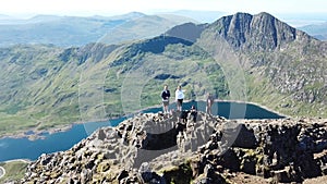 Couple hiking along a knife edge ridge up mount Snowdonia in Wales, UK