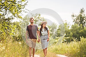Couple Hiking Along Woodland Path. Happy loving man and woman on holiday walking together. Active lifestyle concept. Young people
