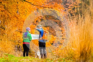 Couple hiking with map in autumn forest