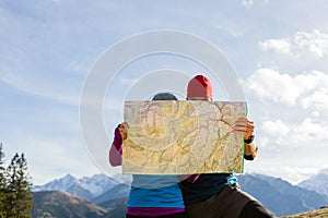 Couple hiking with map in mountains