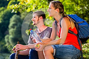Couple hiking in summer drinking water