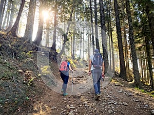 Couple hiking on a sunny day, enjoying mountain nature in autumn