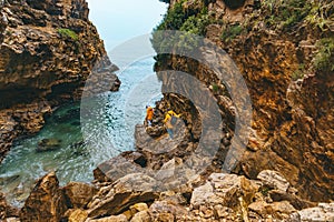 couple hiking to sea beach in canyon